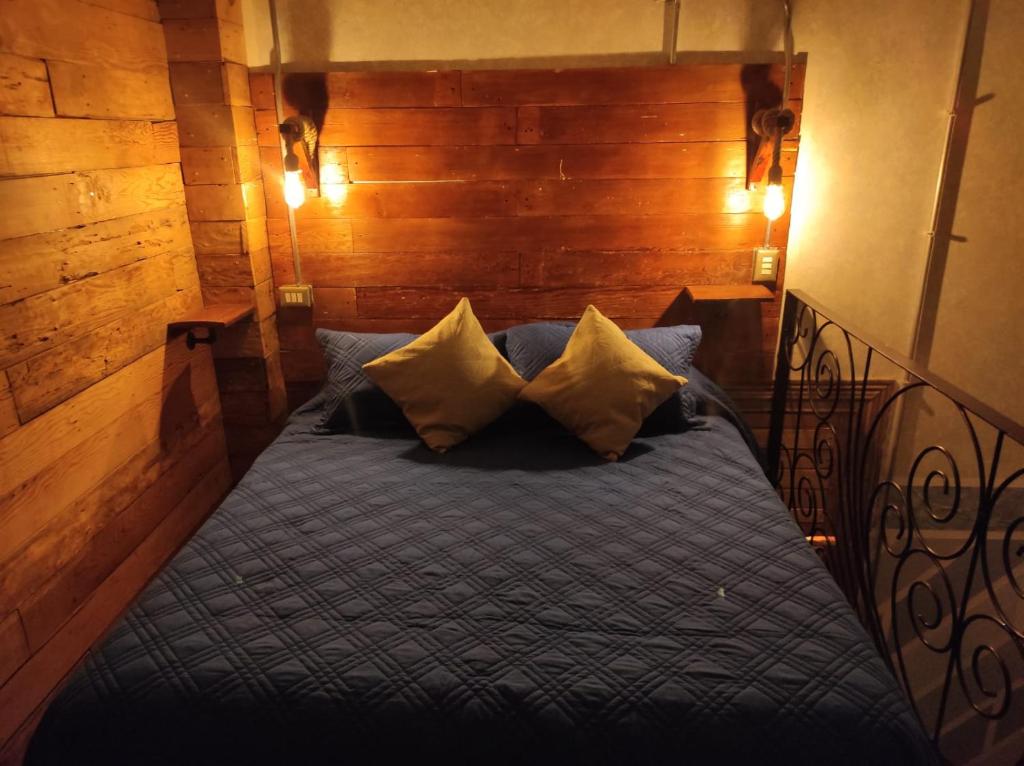 CENTRAL LOFT في إكيكي: غرفة نوم بسرير وملاءات ووسائد زرقاء