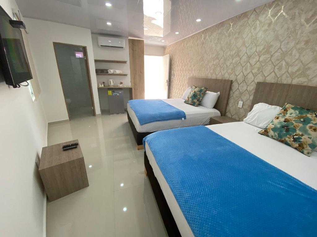 a hotel room with two beds and a tv at Casa hotel boutique habibi - San Andres Islas in San Andrés