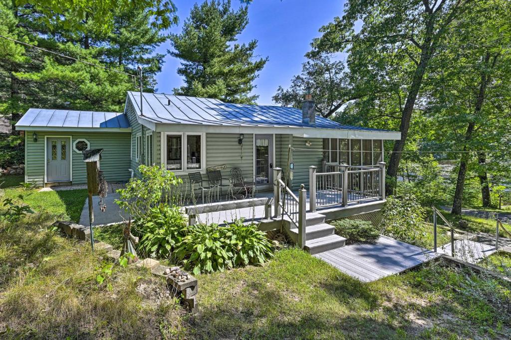 a green tiny house with a porch and a deck at Lakeside Iola Hideaway: Stunning Nature Views in Iola