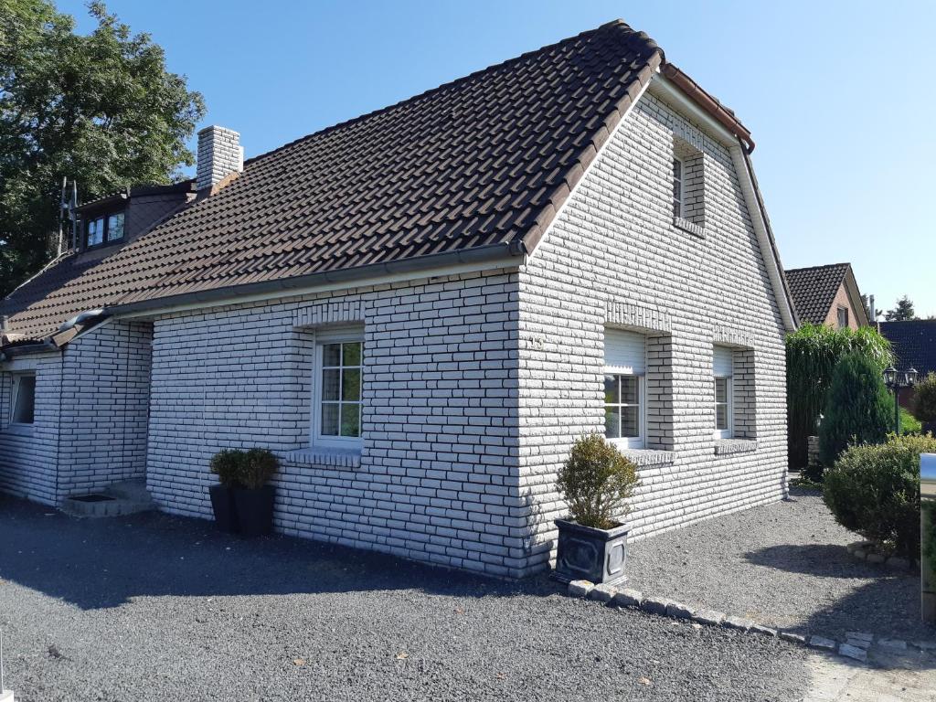 a white brick house with a black roof at Monteurzimmer Ausma Boen 2 - Vakantiehuis Rust & Ruimte in Bunde