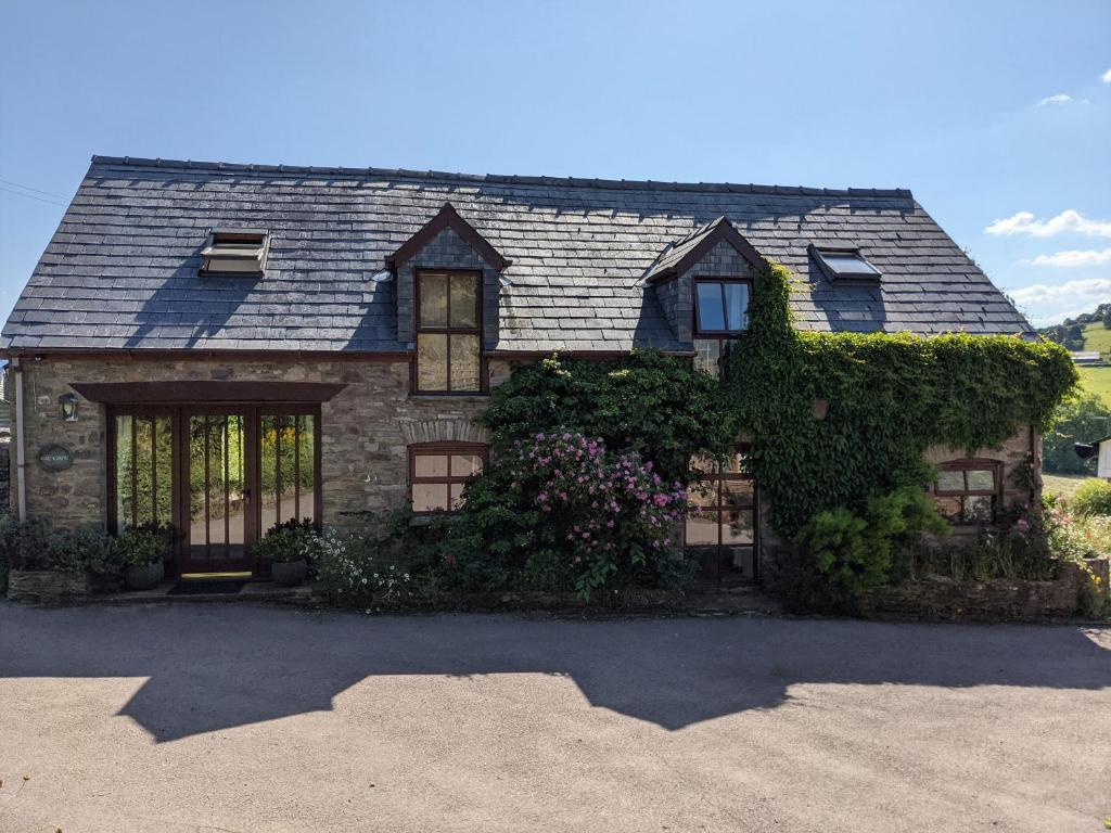 a house with ivy on the front of it at Caecrwn in Brecon