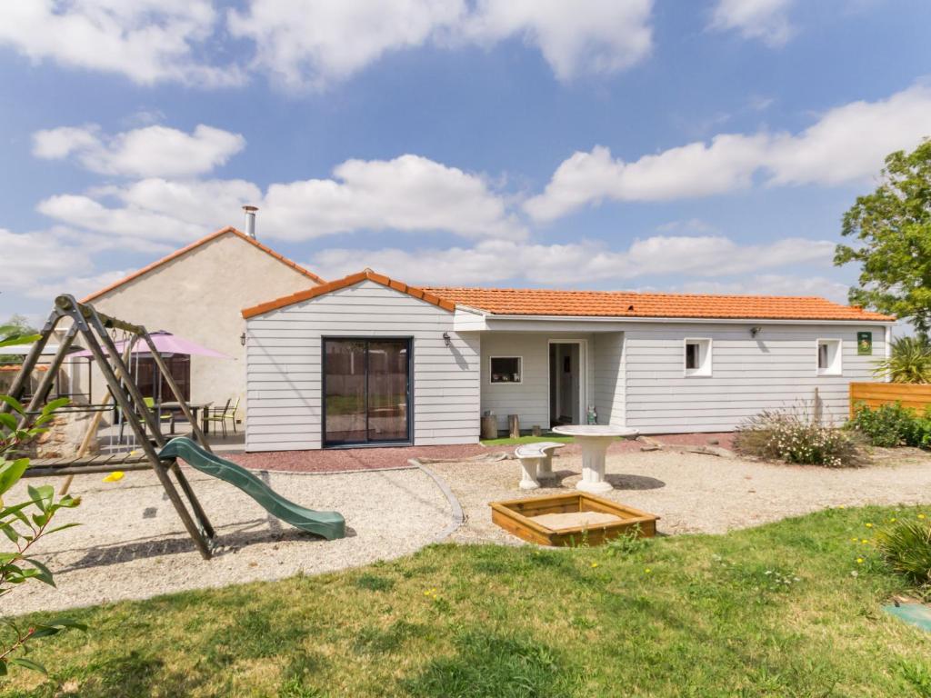 a backyard with a playground and a house at Gîte Saint-Viaud, 4 pièces, 6 personnes - FR-1-306-1047 in Saint-Viaud