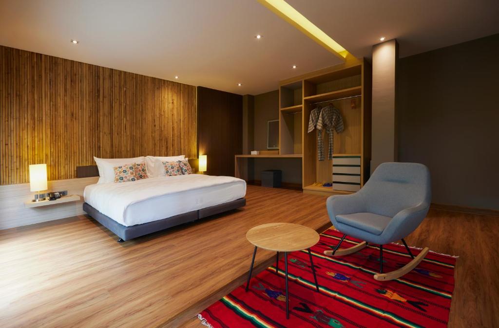 um quarto com uma cama, uma cadeira e uma mesa em Sand Dollar Boutique Hotel em Bang Sare