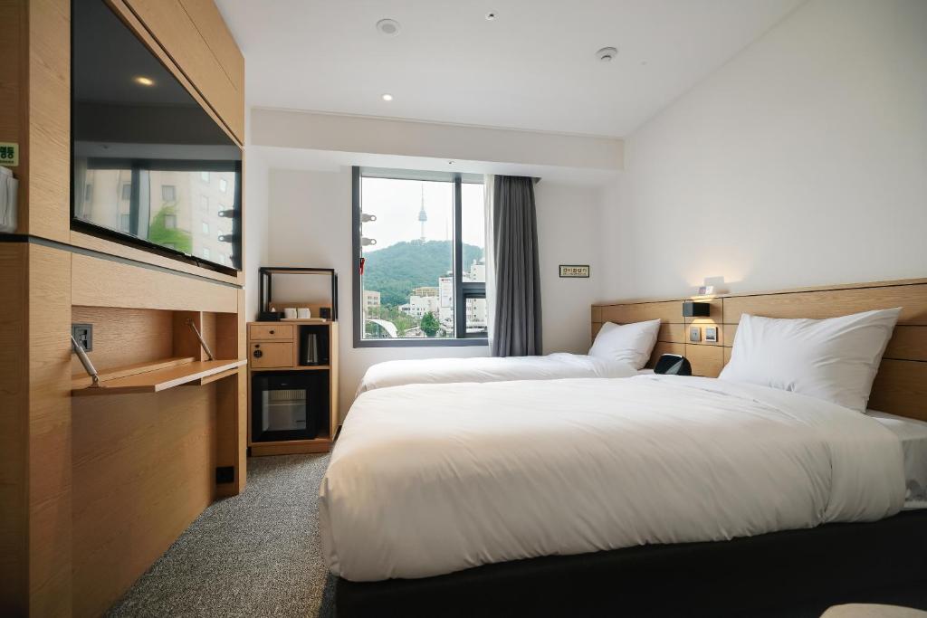Postel nebo postele na pokoji v ubytování Henn na Hotel Seoul Myeongdong