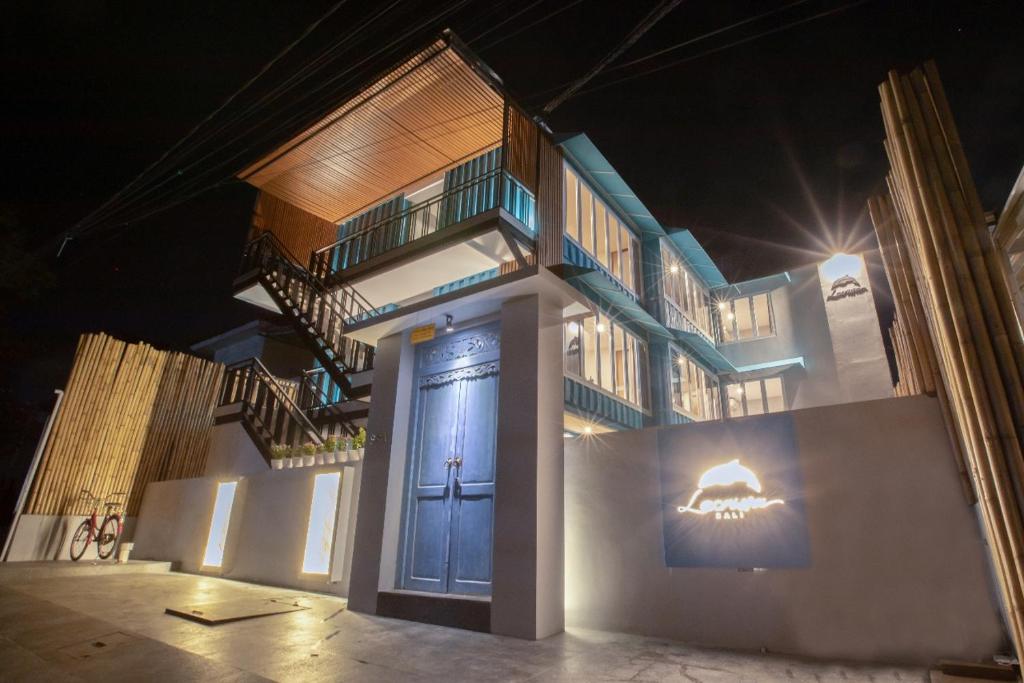 um prédio com uma porta azul e escadas à noite em Lacrissa Bali em Kerobokan