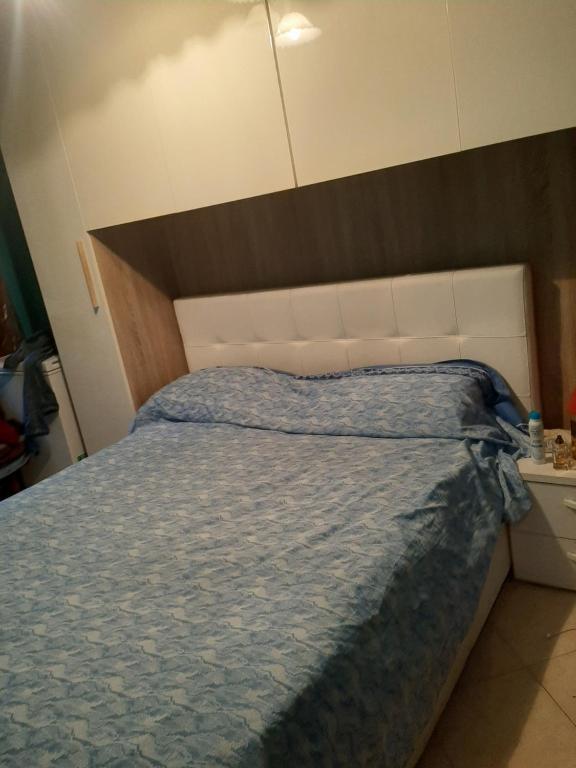 una camera da letto con un grande letto e un piumone blu di Marino a Sassuolo