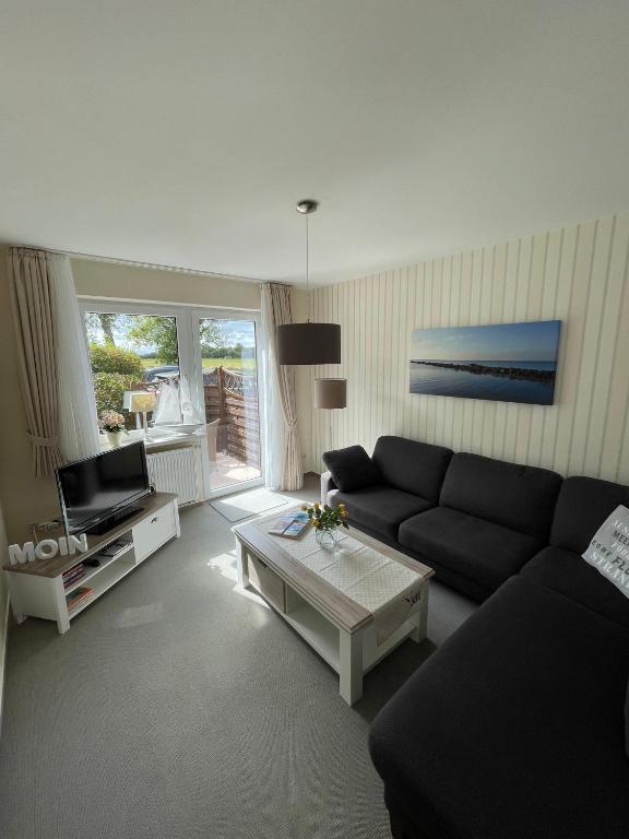 a living room with a couch and a coffee table at Haus-Seeschwalbe-Wohnung-3 in Nieblum