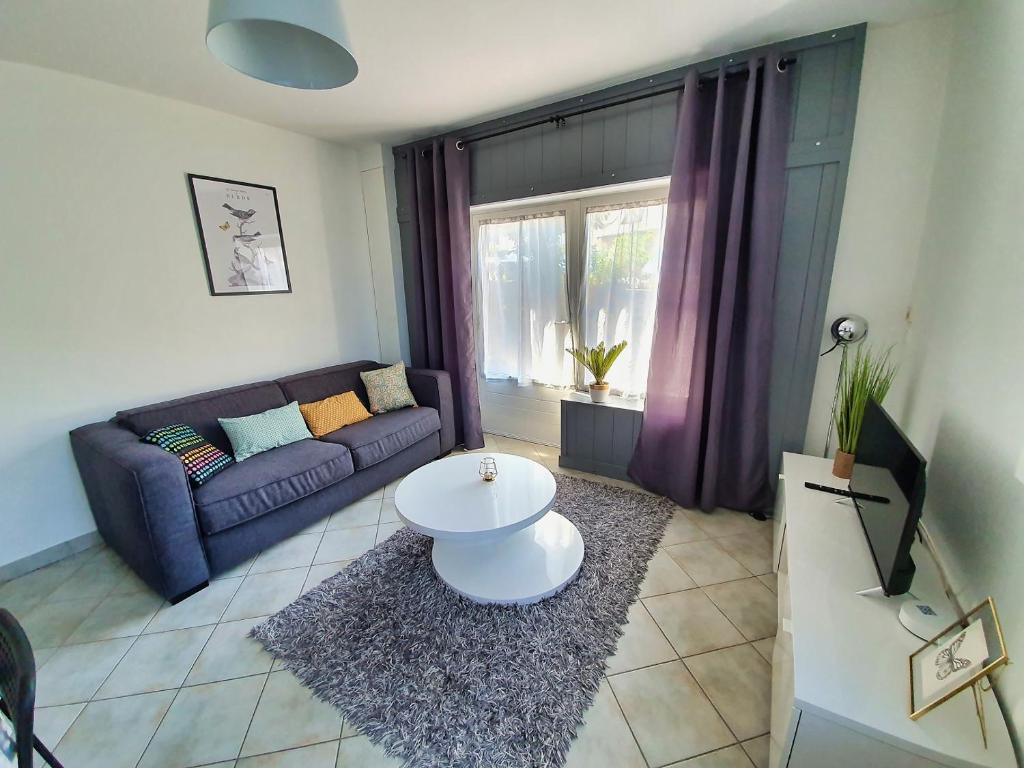 a living room with a couch and a table at Idéalement situé, spacieux et agréable, parking gratuit et classé 3 étoiles in Mende