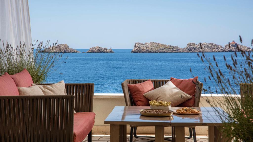 a patio with chairs and a table with a view of the ocean at Royal Neptun Hotel in Dubrovnik