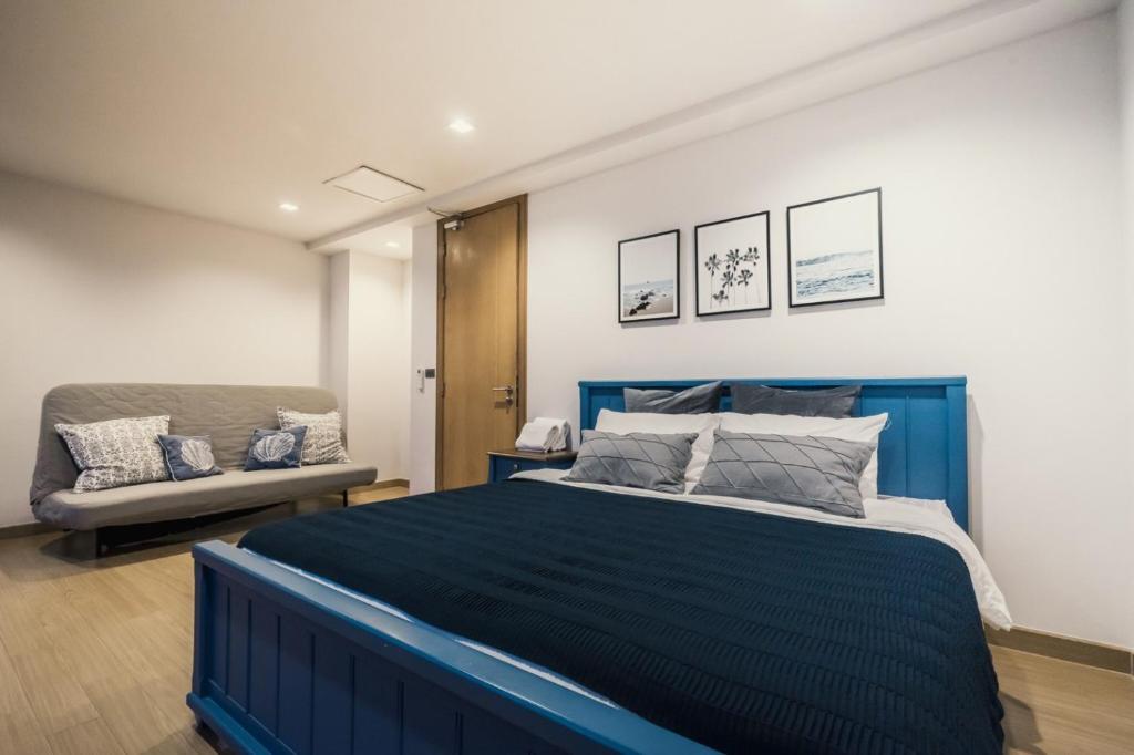 a bedroom with a blue bed and a couch at Sandbox beachfront villa2 in Bang Lamung