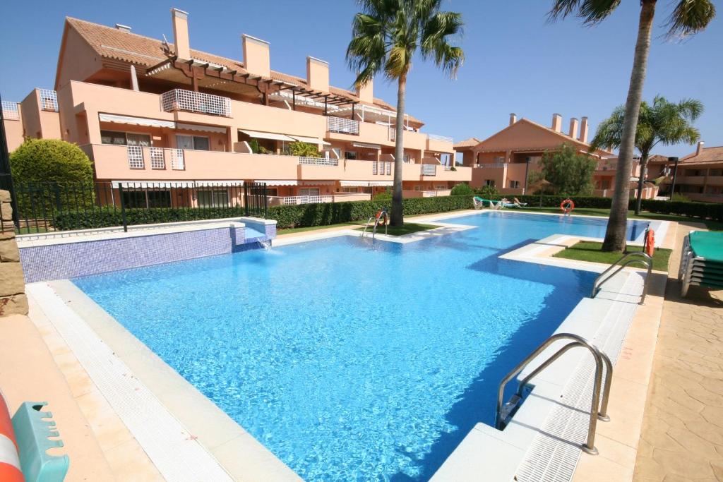 a large swimming pool in front of a building at Ground Floor Apartment, Los Jardines de Santa Maria Elviria in Marbella