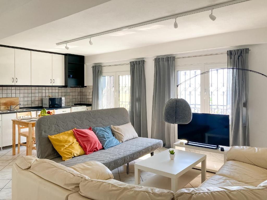 sala de estar con sofá y almohadas coloridas en Sanny's Place, en Kavala