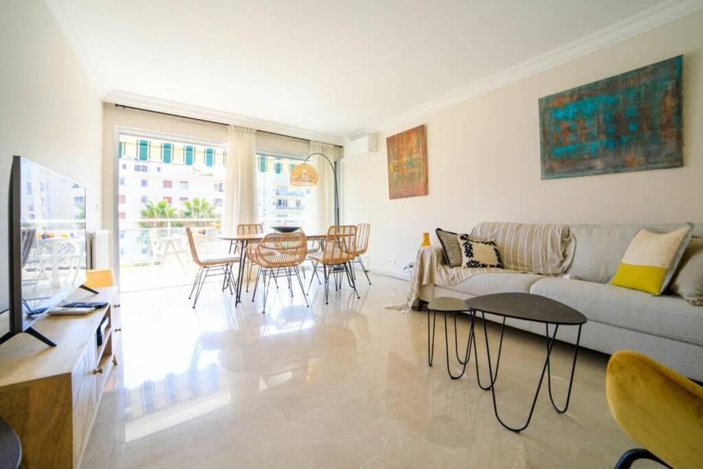un salon avec un canapé, une table et des chaises dans l'établissement Le Bain De Soleil - Le Bain De Soleil 5 star Two bedroom apartment, à Cannes