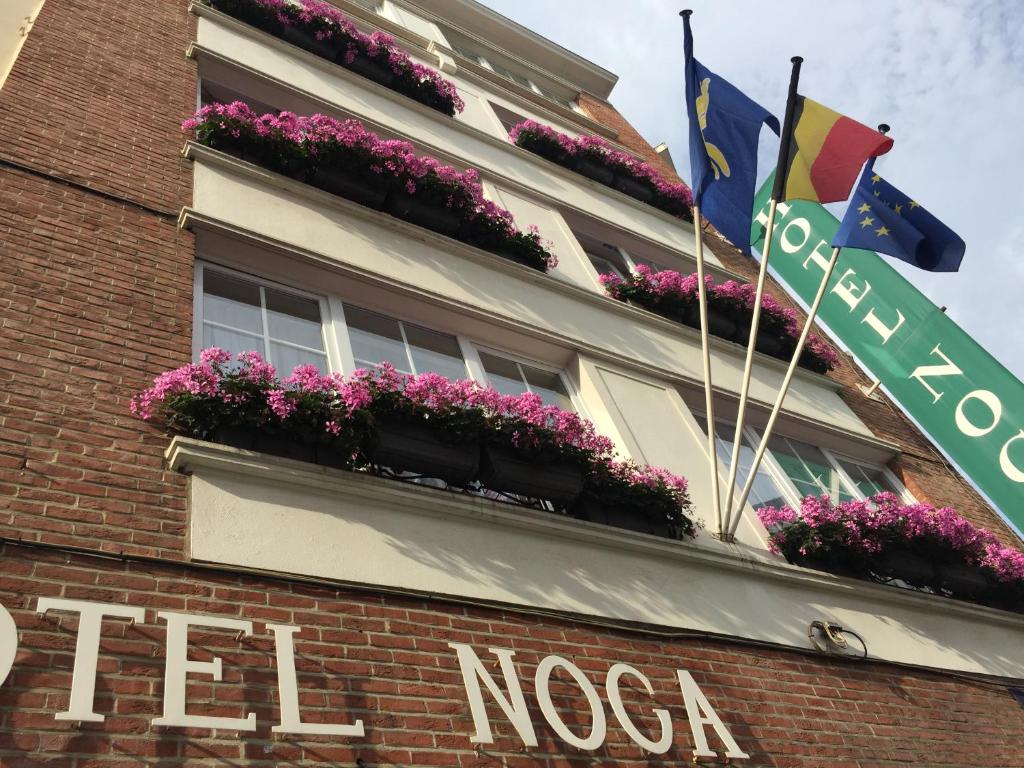 a red brick building with a flag on top of it at Hotel Noga in Brussels