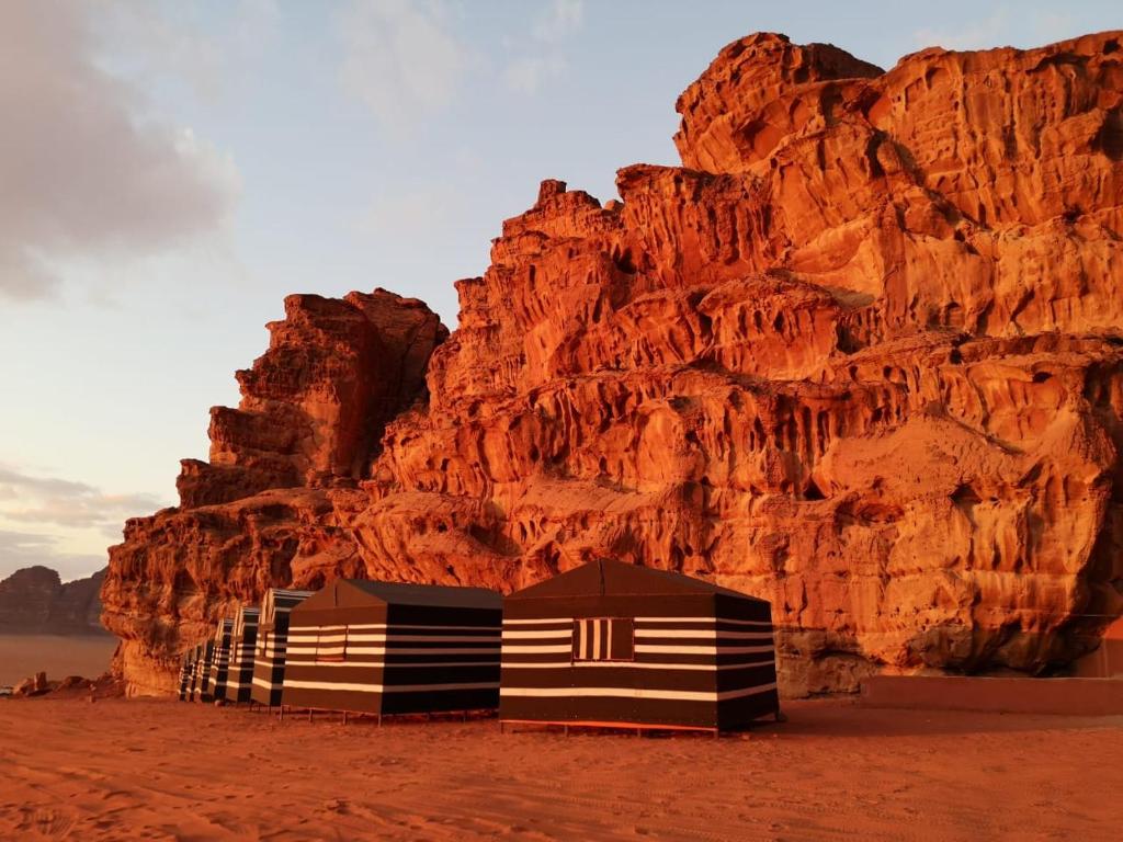 a building in the desert next to a mountain at wadi rum traditional camp in Wadi Rum