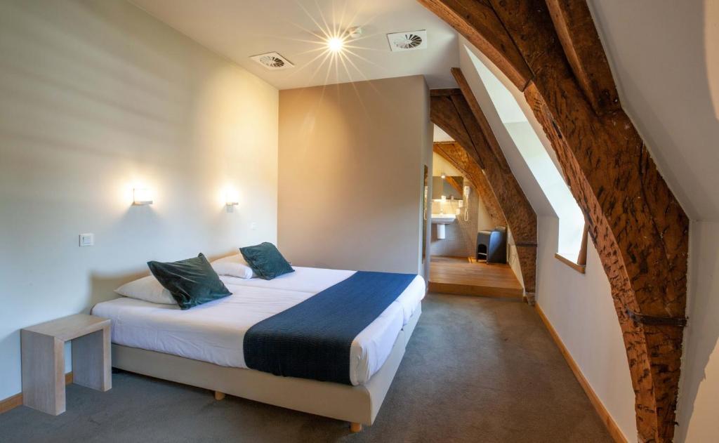 a bedroom with a king sized bed in a room at Hotel The Lodge Heverlee in Leuven