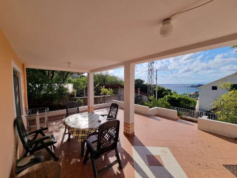 a patio with a table and chairs on a balcony at Дом для семейного отдыха в Утехе, Черногория in Utjeha
