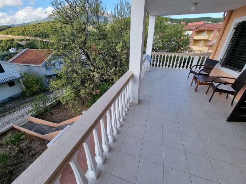 a balcony with chairs and tables on a house at Дом для семейного отдыха в Утехе, Черногория in Utjeha