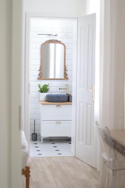 uma casa de banho branca com um lavatório e um espelho em Lechner4 Residence em Szeged