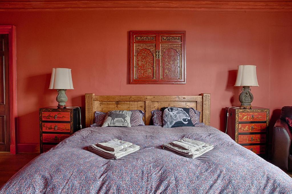 een slaapkamer met een bed met 2 lampen en 2 tafels bij Netherbrae in Edinburgh