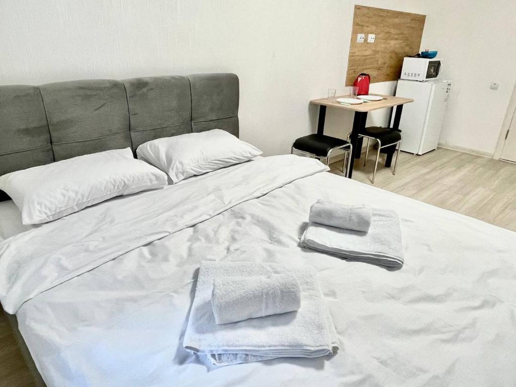 Una cama con dos toallas y una mesa. en Apartments Osokorky House en Kiev