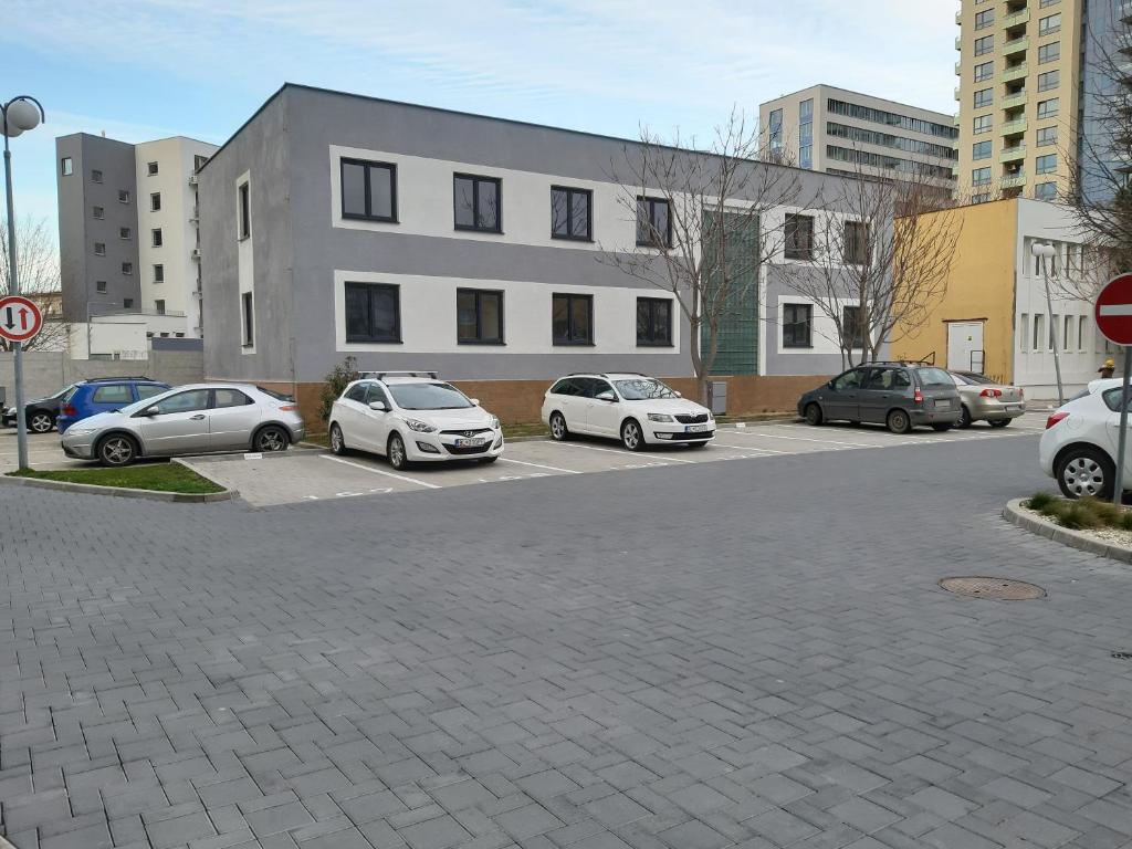a parking lot with cars parked in front of a building at Living Bratislava & Bus Station & Mlynské Nivy in Bratislava