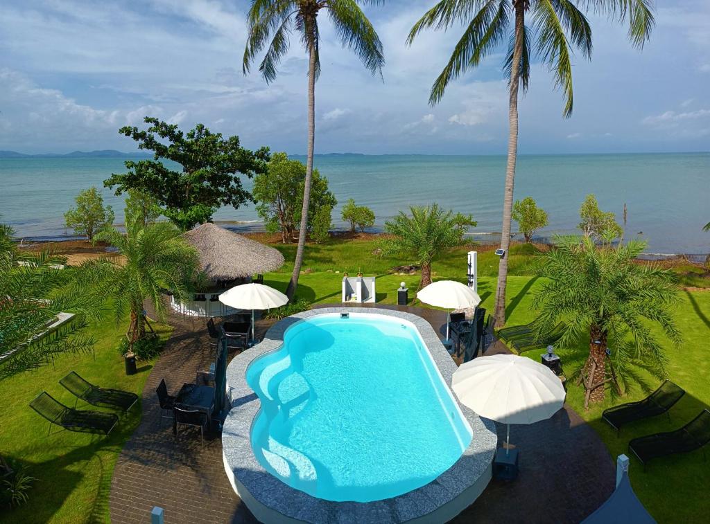 an overhead view of a swimming pool with chairs and umbrellas at Beachfront Pool Villa and Apartment in Ko Chang