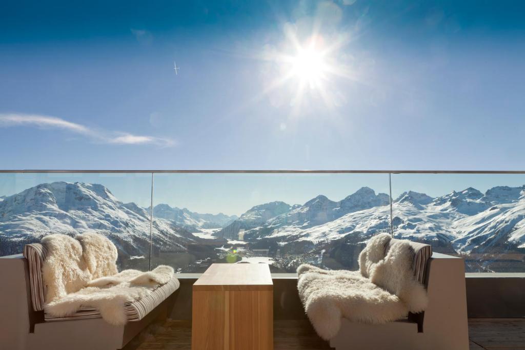 d'un balcon avec deux chaises et une vue sur les montagnes. dans l'établissement Romantik Hotel Muottas Muragl, à Samedan