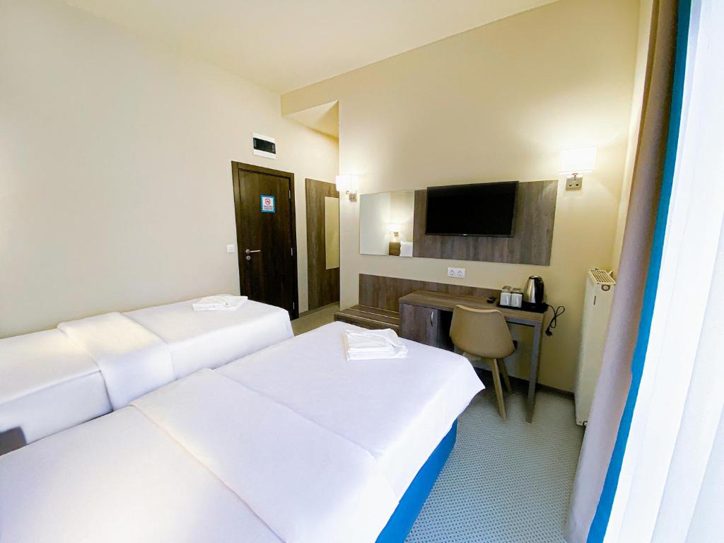 um quarto de hotel com duas camas e uma televisão em Terminal Park em Bischofsheim