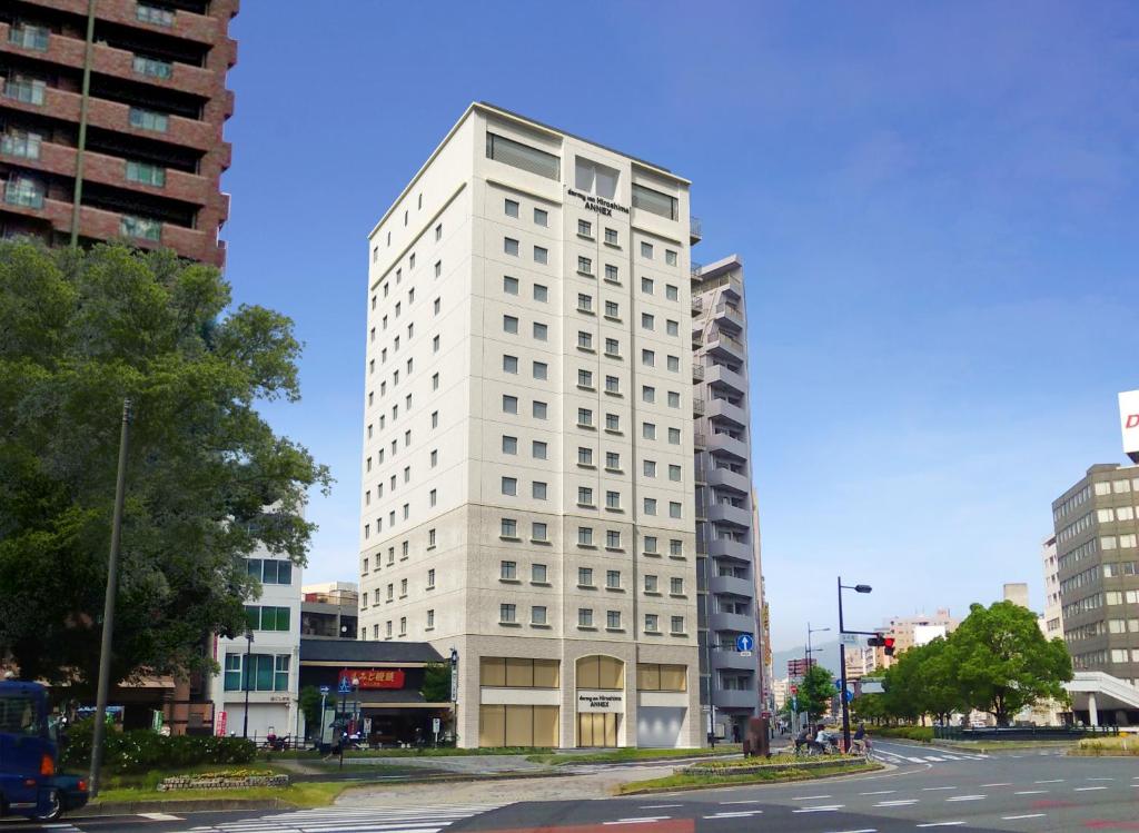 a tall white building on the corner of a street at Dormy Inn Hiroshima Annex in Hiroshima