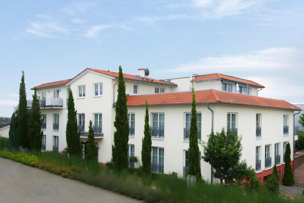 ein weißes Gebäude mit rotem Dach in der Unterkunft Hotel Zielonka in Hochheim am Main