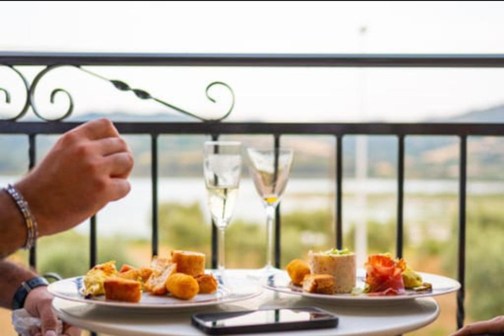 una mesa con dos platos de comida y copas de vino en B&B Albachiara, en Senise