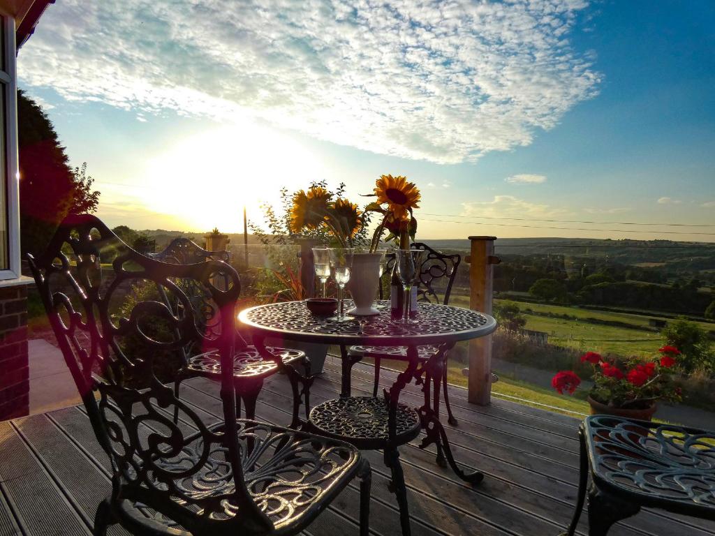 a table and chairs on a deck with a view at The BungalowBarlow in Dronfield