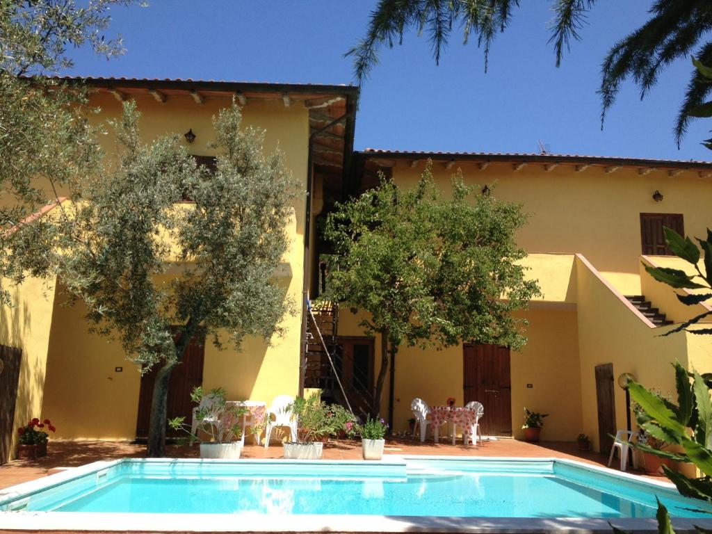 a villa with a swimming pool in front of a house at Il Porto in Tuoro sul Trasimeno
