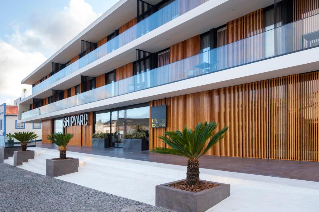 a building with palm trees in front of it at The Shipyard - Angra in Angra do Heroísmo