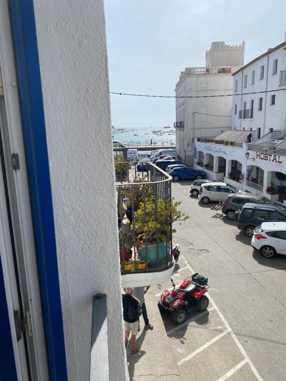 Un hombre está mirando por una ventana en un estacionamiento en Apartament Riera en Cadaqués