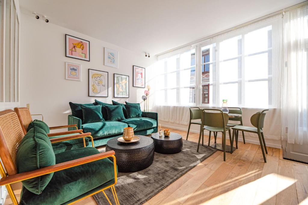 un salon avec un canapé vert et une table dans l'établissement MBM - LOFT MARAIS, à Paris