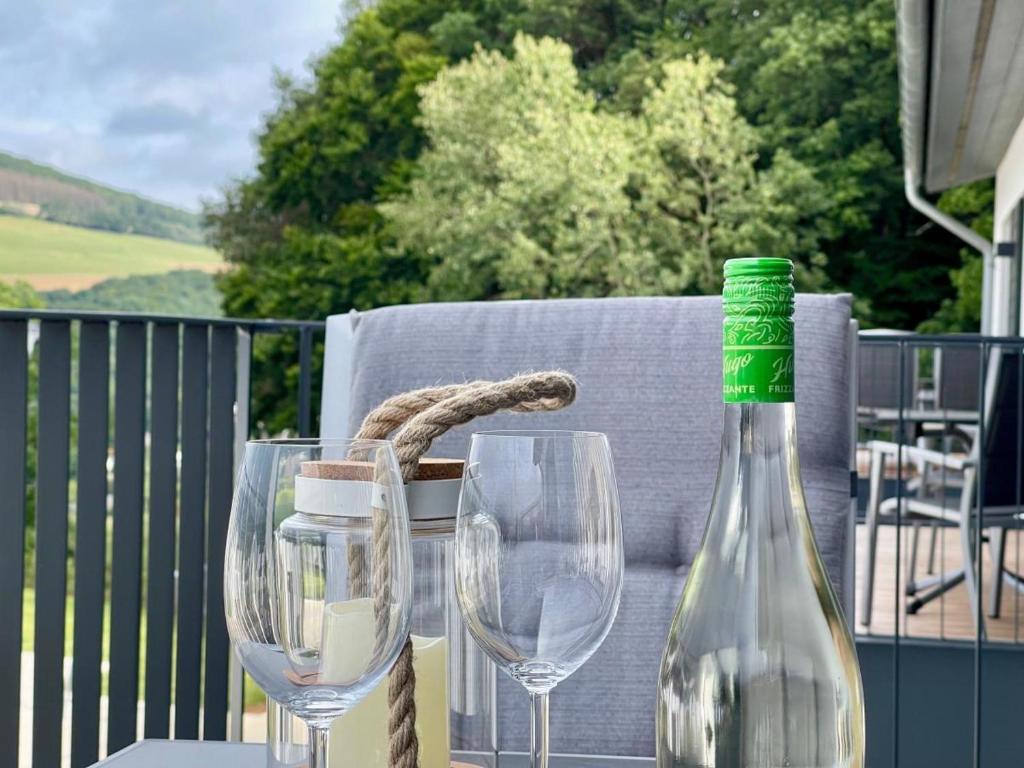 a table with two glasses and a bottle of wine at Sonnenweg 48-4 SAUERLANDBLICK in Heringhausen