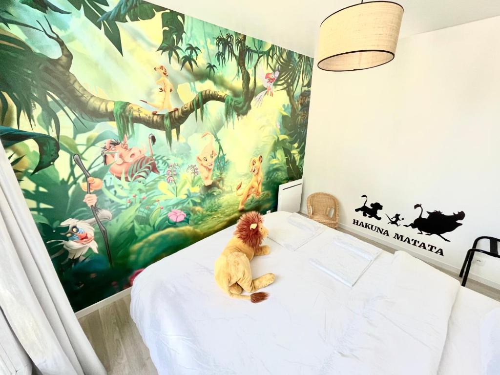 un osito de peluche sentado en una cama en un dormitorio en Lovely Disney House, en Magny-le-Hongre