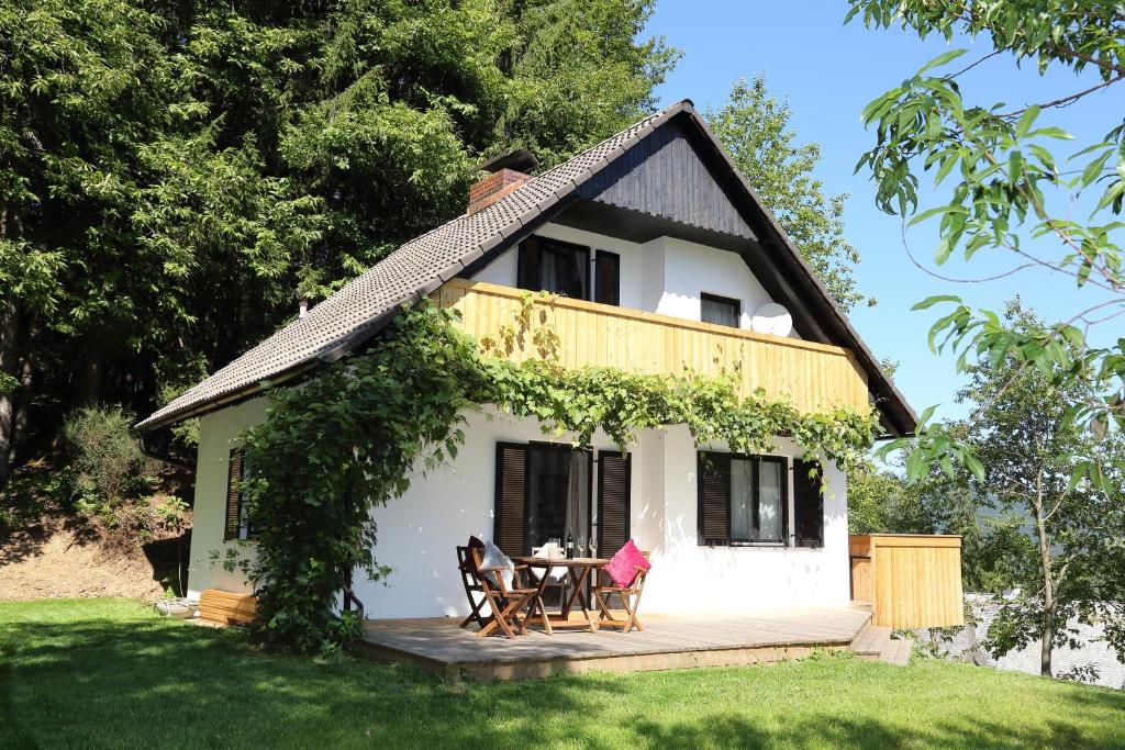 uma pequena casa branca com uma mesa e cadeiras em Ferienhaus Hadernigg em Hadernigg