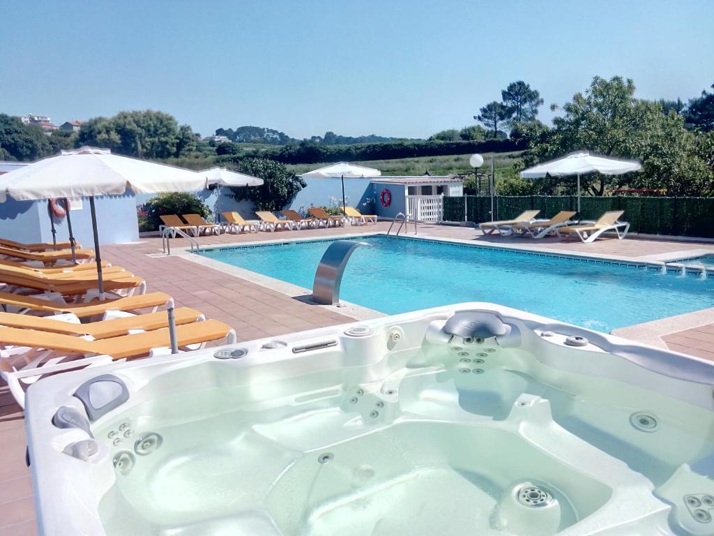 a bath tub sitting next to a swimming pool at Hotel Campomar 3*** Superior in A Lanzada