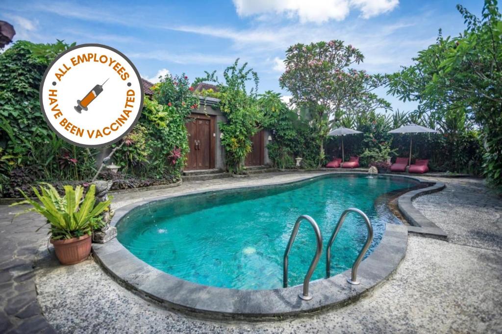 une piscine dans un jardin avec un panneau indiquant le garde de la piscine dans l'établissement Ladera Villa Ubud, à Ubud
