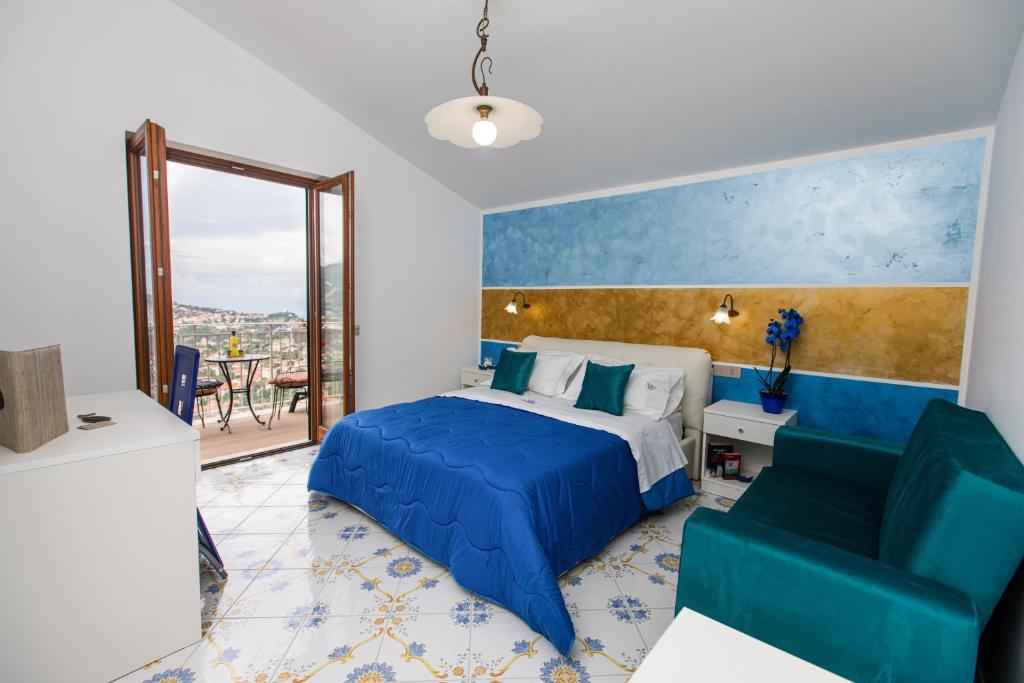 una camera con un letto blu e una sedia di Panariello Palace ad Agerola