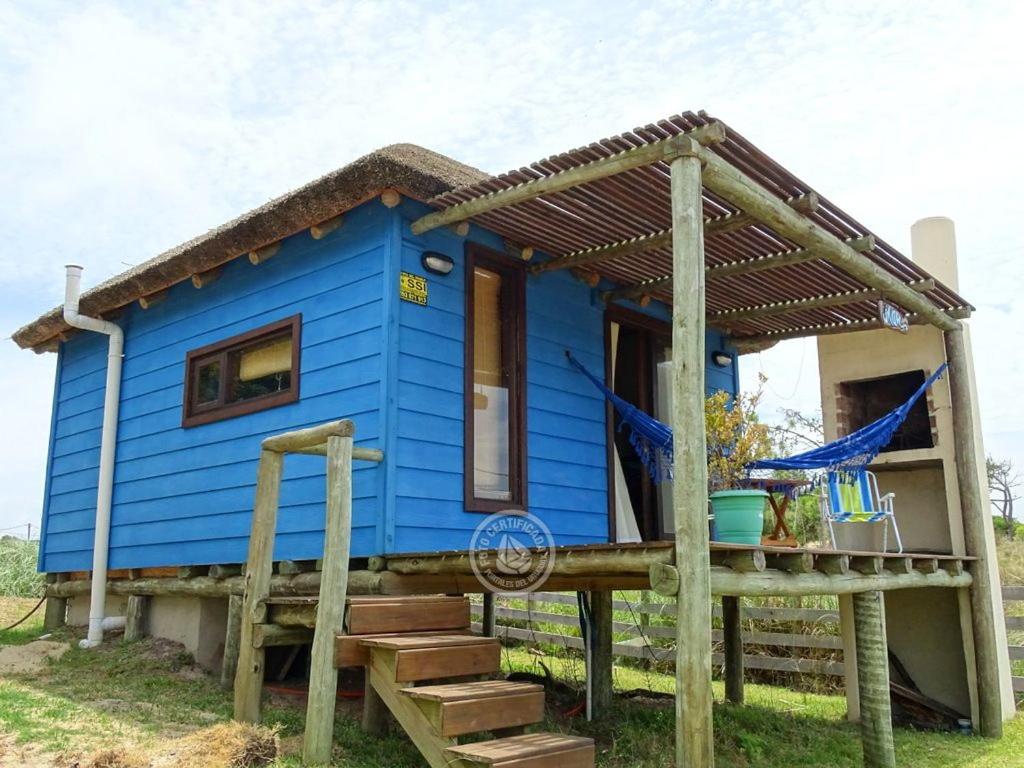 a blue tiny house with a porch and stairs at Mar in Punta Del Diablo