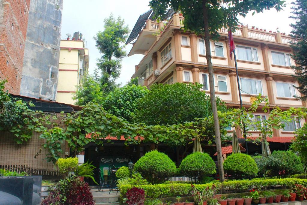 a tall building with a tree in front of it at Hotel Encounter Nepal & Spa in Kathmandu