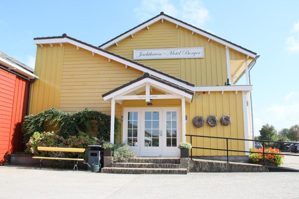 a yellow building with a sign on the front of it at Jachthaven Hotel Borger in Vinkeveen