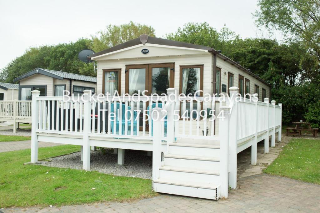 une petite maison de jeux pour enfants avec une clôture blanche dans l'établissement Blackpool caravans Marton mere, à Blackpool