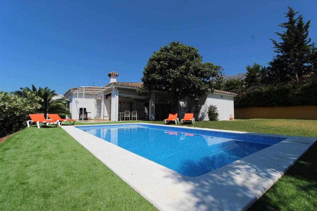 a swimming pool in front of a house at Villa Quimera en Marbella in Marbella