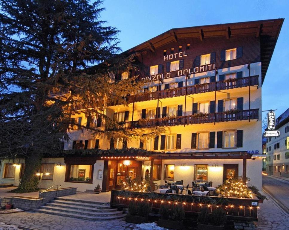 a hotel with christmas lights in front of it at Hotel Pinzolo-Dolomiti in Pinzolo