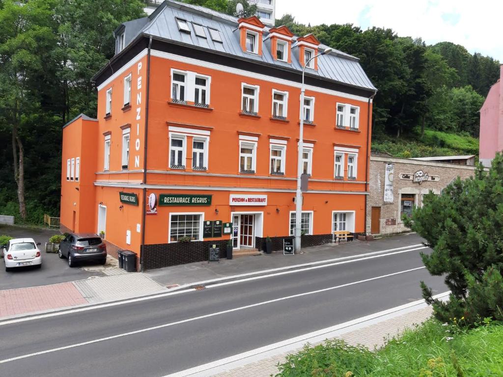 un edificio naranja al lado de una calle en Penzion Haus Regrus, en Jáchymov